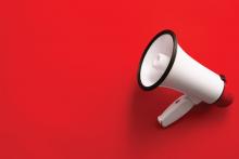 A white megaphone is on a bright red background